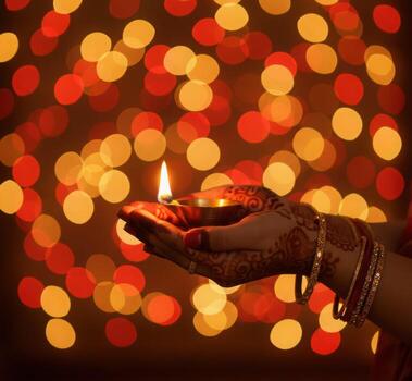 beautifully adorned hand with henna holds a lit diya against a vibrant background of glowing bokeh lights, capturing the essence of diwali warm and festive atmosphere. photo