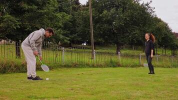 uma casal práticas badminton dentro seus quintal, concentrando em Aprendendo apropriado técnicas e desfrutando qualidade Tempo ao ar livre. a exuberante arredores adicionar para seus experiência Como elas melhorar juntos video