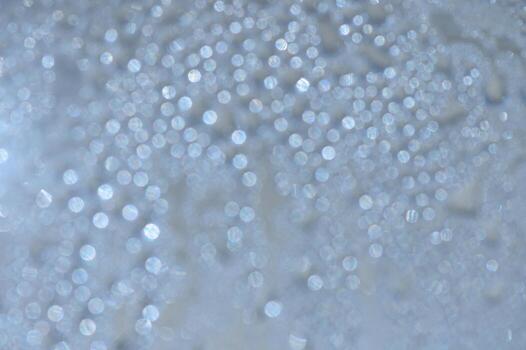 Sparkling droplets dance in sunlight, creating a mesmerizing blur of light and color on a serene surface photo