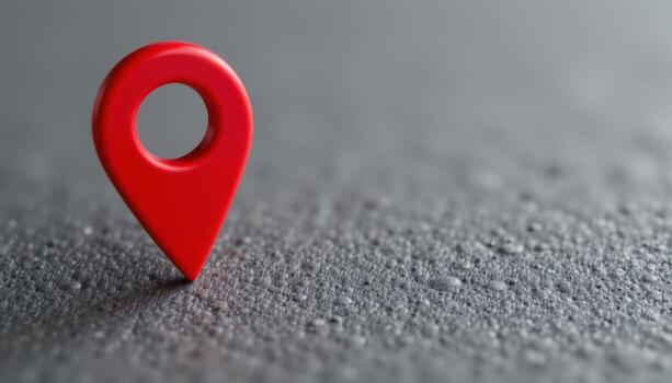 Vibrant red three dimensional map location pin stands on a textured dark gray surface with bokeh effect photo