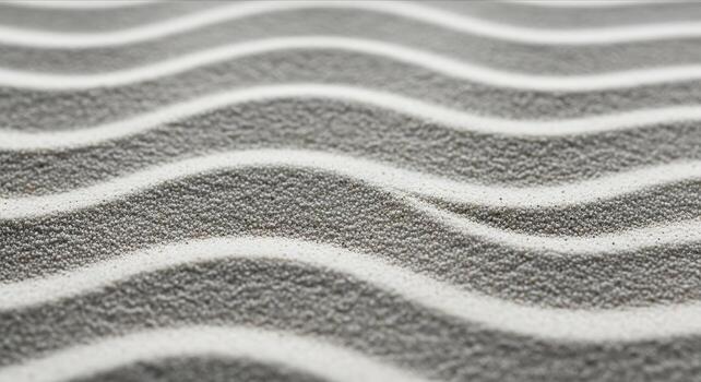 A macro detail shot of pristine desert sand showing elegant, flowing wave patterns and a fine-grained texture under soft, ambient light, creating a serene background. photo