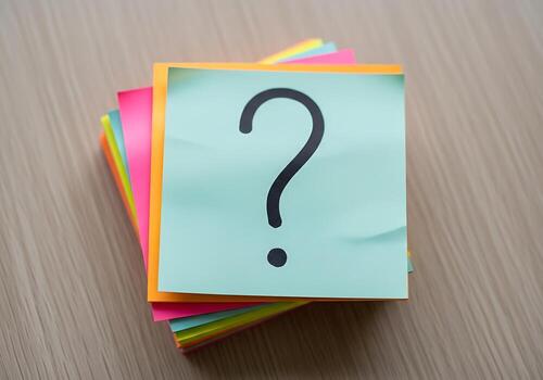 Stack of colorful sticky notes with a large question mark on the top one asking for answers and solutions photo