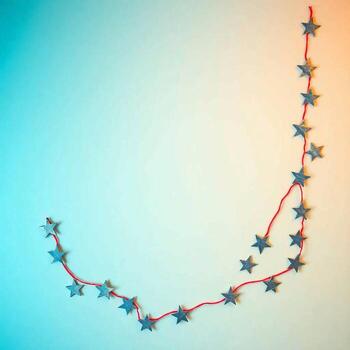 A string of small green stars forms a curved line against a gradient background photo