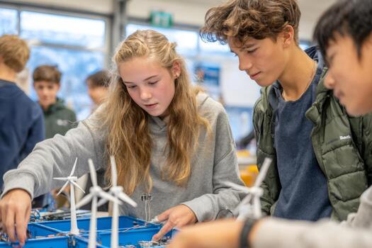 Group of students focuses on assembling wind turbine models during a hands-on learning session in a classroom. They collaborate and share ideas while exploring concepts of renewable energy photo
