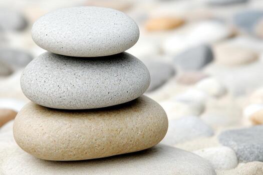Stacked smooth stones on a sunny beach create a peaceful scene photo