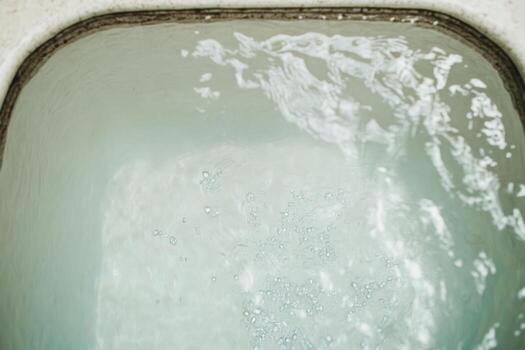 Clear water splashes in a modern sink filled with bubbles at home photo