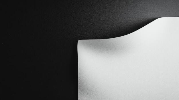 Smooth white paper curling on a dark background creating an artistic contrast photo