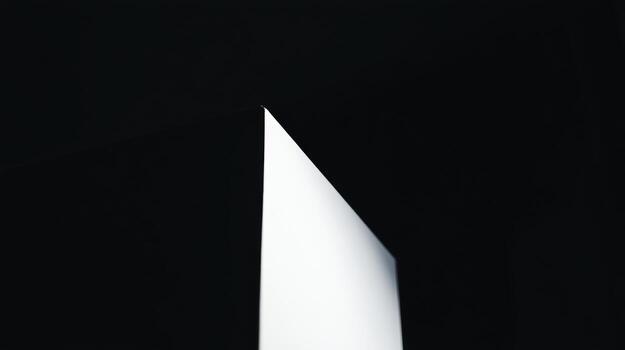 Sharp edge of a geometric shape illuminated by light in dark setting photo