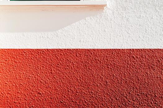 Textured wall with two contrasting colors near a window in sunlight photo