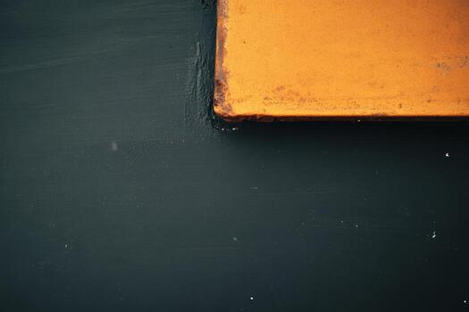 Bright orange corner against a dark textured background adds visual interest photo