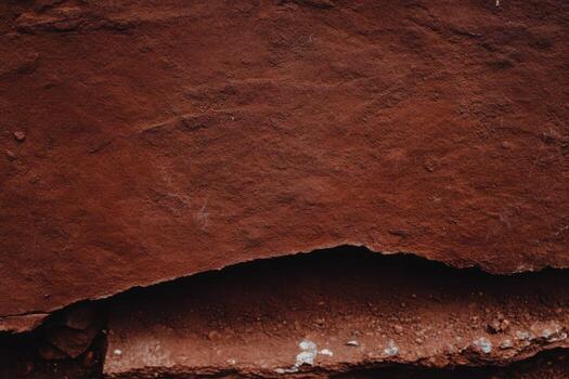 Textured red rock surface with subtle variations in shade and pattern photo