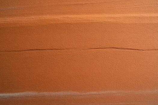 Patterns and textures of smooth orange clay soil in natural landscape photo