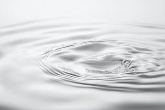 Ripples created by a droplet falling into calm water surface photo