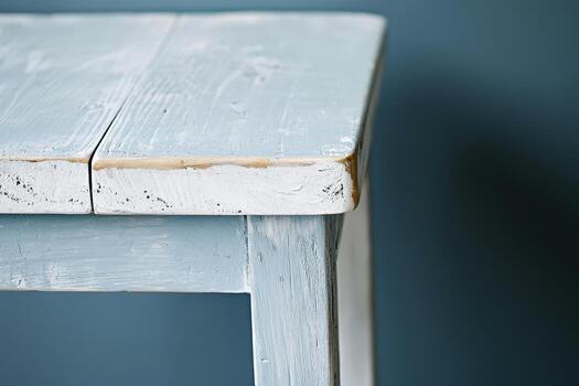 Rustic wooden table with a weathered finish against a blue backdrop photo