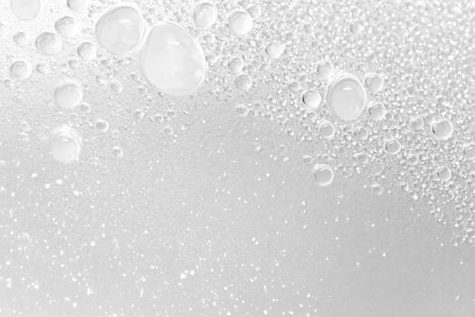 Close-up view of water droplets on a smooth surface in bright lighting photo