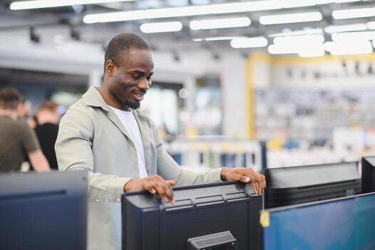Man evaluating computer monitors in store photo