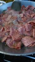 frito cuadrado carne rebanadas candente caliente petróleo con burbujeante superficie y metal espátula emocionante sabroso calle comida escena conjunto con frito rebanado curado carne Cocinando grande pan candente aroma crujiente video