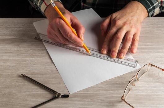 Close-up of a man's hands holding a pencil and a ruler. Working environment on the office table before creating a plan for or project photo