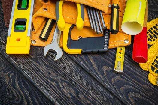 Tools in the bag for carpentry and accessories on a wooden black background. photo