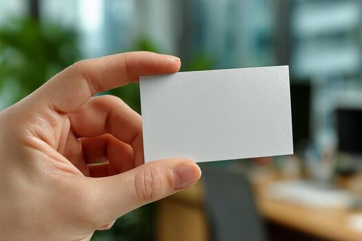 Blank Business Card Held by a Hand in a Modern Office Setting During Daylight Hours photo