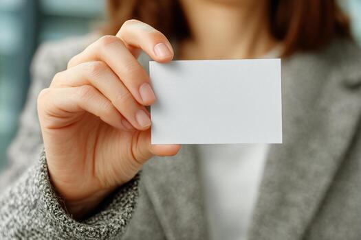 Person Holding a Blank Card in Hand With a Blurred Background in a Professional Setting photo
