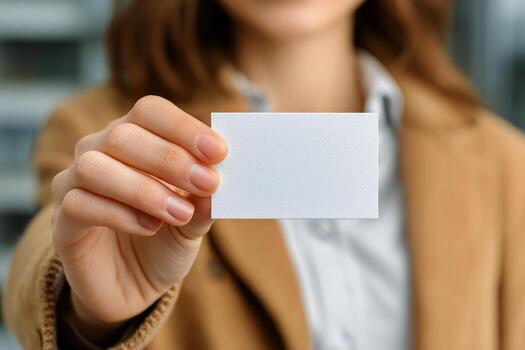 Person Holding a Blank Card in Hand With a Blurred Background in a Professional Setting. photo