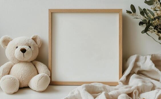 Blank Square Frame on a White Surface With a Teddy Bear and Soft Cloth photo