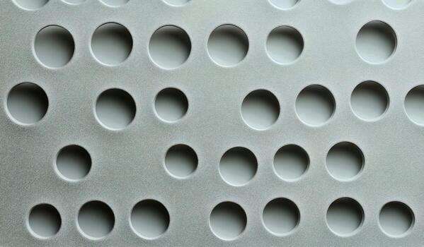 White Surface With Regularly Spaced Round Holes Casting Shadows at Daytime. photo