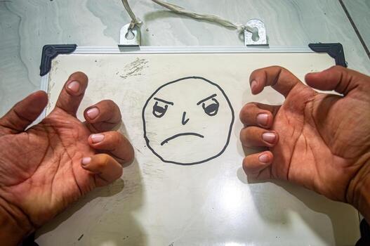 Angry face drawing on whiteboard with claw like hand gestures expressing frustration, emotion, and raw reaction in a bold, creative visual concept. photo
