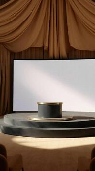 Empty stage with a circular podium and a large projection screen set with draped curtains photo