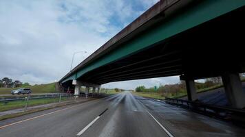 körning bil på de motorväg under de utbyte bro på molnig väder. pOV se från de främre passagerare sittplats. video