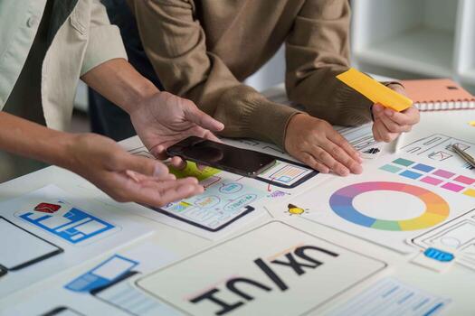 Digital Design Collaboration. Team members discussing mockups and color choices on a tablet. photo