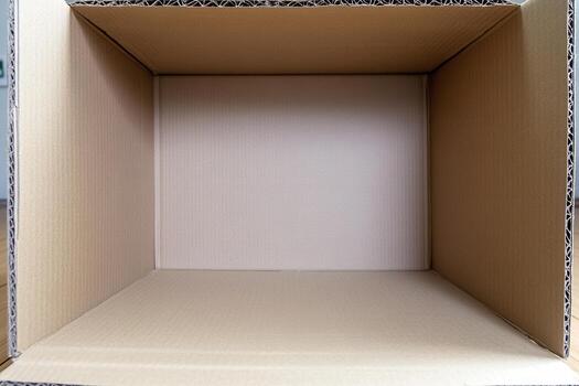 An empty cardboard box on a wooden table photo