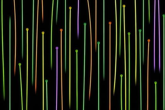 Vertical lines of vibrant, glowing color, with small dots at the tops photo