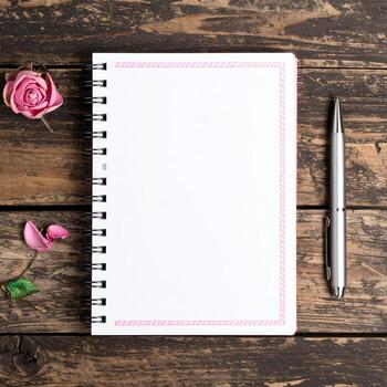 Notebook with pink rose on wooden background photo