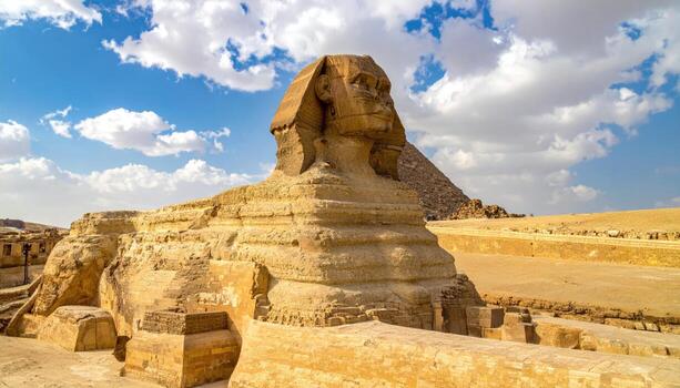 Ancient Sphinx with pyramids in background photo