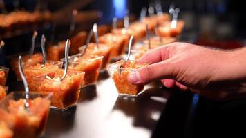 caramella bar su festeggiare festa evento. mano è assunzione il colorato torta dolce tazze con minuscolo cucchiai su Schermo In piedi. video