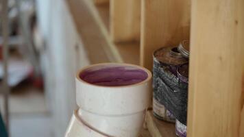 Close-up view of PVC plumbing pipe joint sealed with purple primer adhesive inside a construction site video
