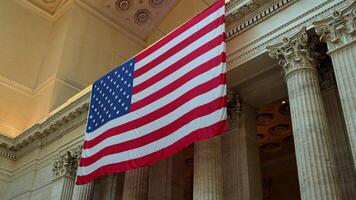 grande americano bandiera su il edificio con colonne, largo giù per su Visualizza metraggio video