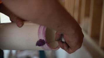 Close-up view of applying purple adhesive glue for sealing PVC plumbing pipe joint on construction site video