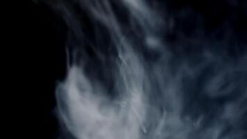 Vape smoke. Thick gray cigarette smoke blows out from the left into the frame on black background. video