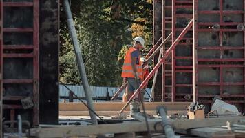 Construction Workers Installing Wall Formwork, Team In Safety Vests Adjusts Supports And Frames For Concrete Pouring, Active Work Scene On Building Site video