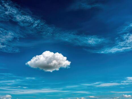 A cloud is floating in the sky above a field photo