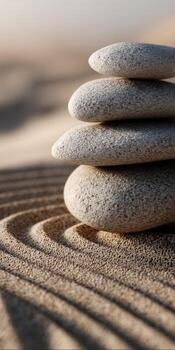 Zen stones stacked on top of each other in the sand photo