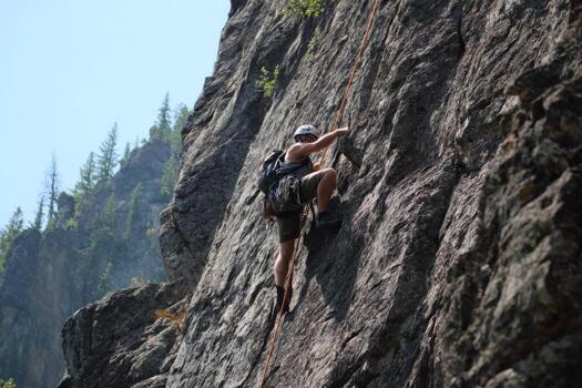 A man climbing up a rock face photo