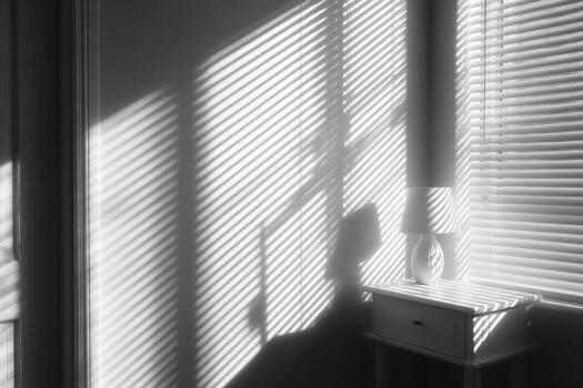 Black and white photo of a window with blinds