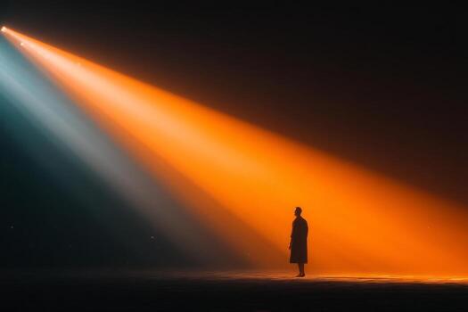A man standing in front of a spotlight photo
