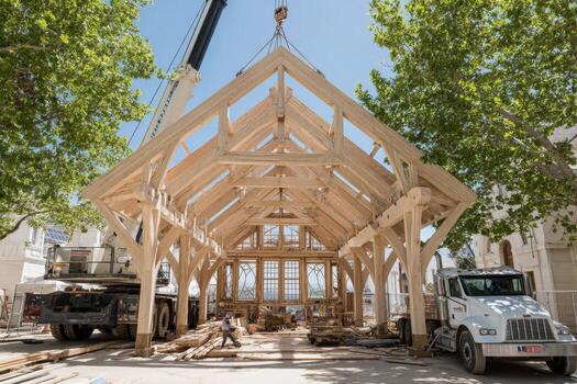 A crane is lifting a wooden structure on a street photo