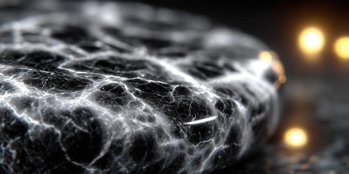 Intricate details of a textured marble stone with glowing highlights against a dark backdrop. photo