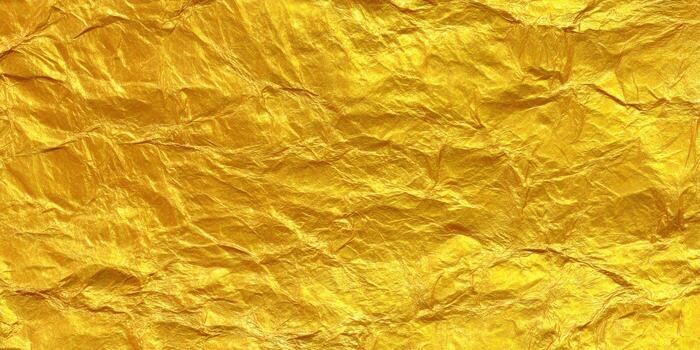 A close-up view of golden foil paper with a textured and crumpled surface. photo